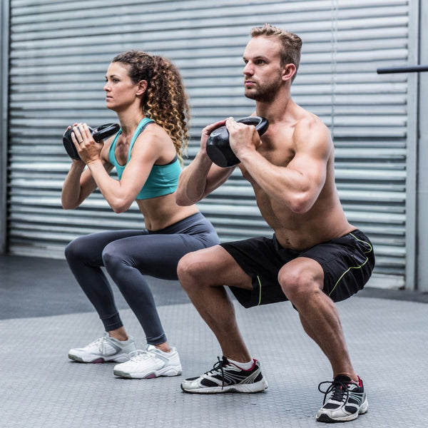 Two people exercising with dumbbells outdoors.
